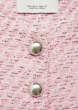 Chaqueta de tweed rosa con cuello redondo, cierre frontal con botones plateados, dos bolsillos de parche delanteros, corte entallado, forro interior y mangas largas.