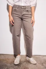 Jean de mujer color marrón topo, tiro medio, con corte barrel y puño doblado. Presenta costuras decorativas en la zona de las rodillas.