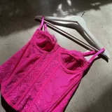 Corset fucsia de encaje con breteles finos regulables.