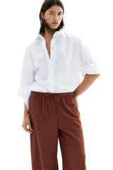 Pantalón marrón de punto texturado, corte holgado, tiro alto, piernas rectas, elástico en la cintura y cordón para ajustar.