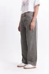 Pantalón jean celeste de tiro medio, corte amplio y redondeado.