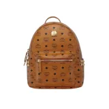 Mochila de lona revestida color marrón con monograma de la marca en toda la superficie, tachuelas metálicas doradas bordeando los bolsillos laterales, cierre bidireccional, asa superior reforzada, correas ajustables, dos compartimientos en la parte interior uno de ellos ideal para trasladar una tablet, bolsillos interior y exterior con cierre y placa metálica grabada con el nombre de la marca en la parte frontal.
