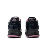 Championes New Balance modelo 1906R, color negro con detalles en rosa.
