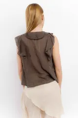 Blusa blanca de algodón con escote en V, volados en el frente y mangas cortas.