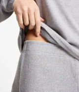 Conjunto de pijama de punto liviano color gris, compuesto por una blusa de mangas largas y cuello redondo, y un pantalón largo con cintura elástica.