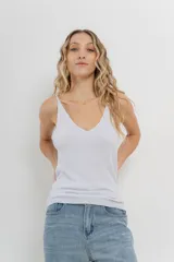 Musculosa amarilla de hilo con brillo sutil, de calce ajustado y breteles finos.