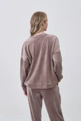 Buzo de terciopelo color marrón, de corte holgado, cuello redondo y manga larga.