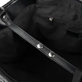 Cartera tipo shopper color negro, confeccionada en símil cuero texturizado. Tiene doble asa de mano, correa bandolera regulable y herrajes plateados. El acceso es con cierre y cuenta con un compartimento principal con un bolsillo interno con cierre y dos bolsillos abiertos. El interior está forrado en tela de algodón y poliéster.