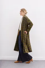 Kimono largo verde oliva con estampado batik en tonos morados. Tiene mangas largas, bolsillos laterales y se ata a la cintura con un cinturón blanco y negro.