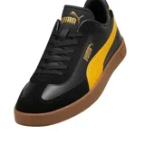 Championes Puma Club LI Era de cuero sintético negro con detalles en amarillo y suela color caramelo.