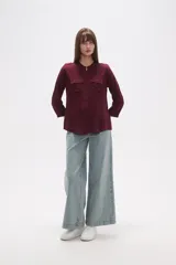 Camisa de manga larga con cuello mao y estampado paisley en tonos blanco, verde oliva y rosado. Presenta un calce holgado y bolsillos frontales.