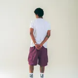 Bermuda de nylon color gris oscuro, con cintura elastizada con cordón, bolsillos laterales y bolsillos cargo con solapa. Estampado blanco con diseño de casa en la pierna izquierda.