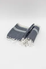 Lona de playa rectangular con diseño estampado a rayas rojas y blancas.