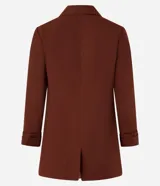 Blazer sastre femenino confeccionado en crepé color marrón, de modelo oversized y comprimento alargado. Sin estampa, posee bolsillos y detalle de pliegues en los puños.