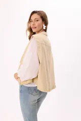 Chaleco color beige estilo cargo con lavado suave, bolsillos frontales y botones negros.