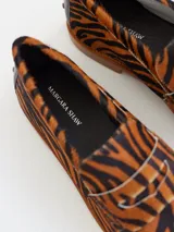 Mocasines con estampado animal print de tigre, confeccionados en cuero.
