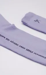Medias de caña media color lila con detalle de tijeras y texto "Ropa sin género para seres humanos".