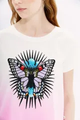 Remera blanca de algodón peruano con teñido artesanal di dye en degradé rosado. Estampa frontal de mariposa bordada en hilo.