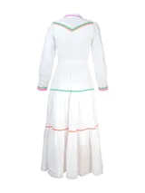 Vestido camisero largo de lino blanco con cuello camisero, cierre frontal con botones y cinturón de lazo. Presenta detalles de bordado ondulado en colores verde, naranja y fucsia en cuello, bolsillos, puños y ruedo.