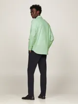 Camisa de hombre Tommy Hilfiger, modelo 1985 TH Flex, color verde claro. Corte regular, cuello abotonado, mangas largas con puños abotonados y logo bordado en el pecho. Confeccionada en algodón Oxford orgánico con Flex Technology.