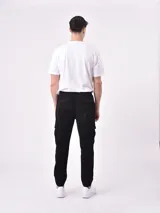 Pantalón jogger gris oscuro con cintura elástica ajustable con cordón, bolsillos laterales y bolsillo cargo con solapa en la pierna. Puños elásticos en los tobillos.