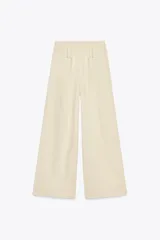 Pantalón ancho color verde oliva confeccionado en lino. Tiro alto con cintura elástica ajustable con cordón y pinzas delanteras. Presenta bolsillos laterales y traseros. Incluye cinturón de la misma tela con apliques metálicos.