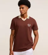 Camisa polo marrón con textura, cuello con detalle contrastante en beige y logo bordado en el pecho.