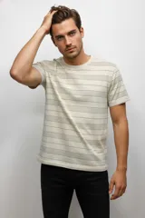 Remera de manga corta color beige con cuello redondo, confeccionada en algodón y con un estampado de rayas horizontales discontinuas en color marrón oscuro.
