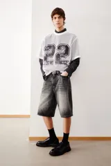 Short de denim de algodón rígido color gris oscuro con efecto lavado. Diseño de cinco bolsillos, corte holgado y tiro caído.