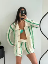 Conjunto tejido a crochet color crudo con rayas verticales verdes, compuesto por un cardigan con botones y shorts.