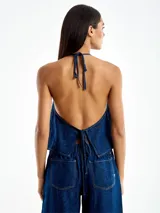 Top de jean azul con cuello halter y espalda descubierta.
