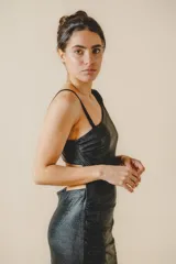 Vestido largo de fiesta negro brillante, de un solo hombro, con abertura lateral en la falda y corte ajustado al cuerpo.