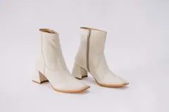 Botas plateadas de cuero con caña media, cierre lateral con cremallera y tacón geométrico.