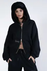 Campera negra con cierre frontal, capucha y logo de la marca en el pecho.