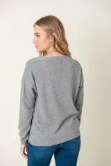 Cardigan celeste de lana con escote en V y botones marrones.