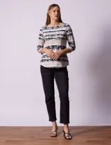Remera de algodón estampada con rayas horizontales en tonos beige, blanco y negro. Tiene mangas 3/4 y escote a la base.