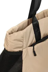 Bolso color beige con asas de cinta negra, bolsillos laterales de red negra y cierre superior con cremallera.