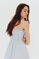 Vestido corto celeste de algodón con cuerpo fruncido, escote cuadrado y breteles spaghetti dobles. Costura fruncida en la cintura y falda con vuelo. Forrado.