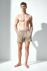 Short de baño color marrón con estampado de palmeras, con cintura elástica ajustable con cordón, bolsillos laterales y trasero con cierre autoadherente.