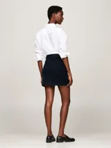 Minifalda de pana azul marino con cierre de cremallera y botón, estilo de cinco bolsillos y logo de Tommy Hilfiger bordado en el bolsillo trasero.
