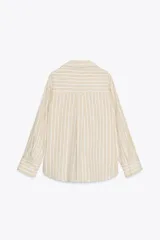 Camisa de algodón a rayas verticales color beige y blanco, de corte recto, con cuello solapa, escote en pico, manga larga con puños y cierre frontal con botones.