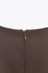 Vestido marrón sin mangas con cuello redondo y falda con pliegues.