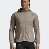 Campera deportiva color gris topo, con capucha y cierre frontal completo. Fabricada en tejido ripstop semitransparente, con logo 2XU en el pecho y detalle de líneas rojas en el brazo.