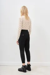 Pantalón tipo babucha negro, confeccionado en gabardina elastizada, con cintura regulable mediante cordón y puños ajustados en flame. Posee bolsillos diagonales delanteros y bolsillos con solapa y botón traseros.