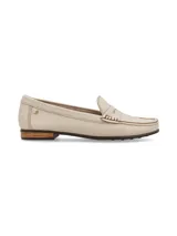 Mocasín de cuero color crema, con suela marrón y detalle de remache metálico con el logo de la marca.