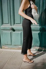 Pantalón negro de tiro alto con corte mini flare y volantes con estampado de lunares en el bajo.