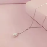 Collar estilo 'Y' o 'Lariat' con cadena de plata 925, un punto de unión con una circonia engarzada y un colgante final de perla de río de forma ovalada.