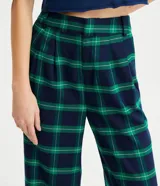 Pantalón de corte wide leg con estampado de cuadros en tonos azul y verde. Presenta pliegues en la cintura y trabillas para cinturón.