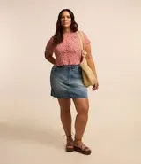 Pollera corta de jean de lavado diferenciado, con trabillas en la cintura, cierre delantero y bajo con corte a hilo.