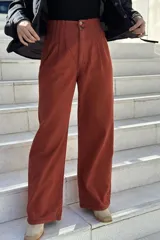 Pantalón de jean color beige, de corte ancho, recto y tiro alto. Tiene elástico y pinzas en la pretina.
